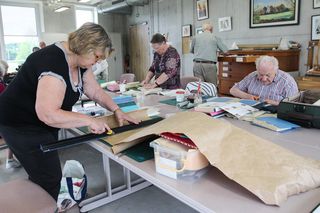 Atelier reliure dans une grande salle d'acitvités artistiques à l'étage de l'Espace Vie Locale.